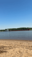Mother and child enjoy sunny beach day near river