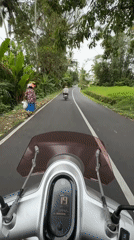 Motorcyclist rides silver Yamaha scooter on Baturiti road