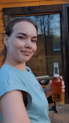 Woman enjoys beer outdoors near gazebo