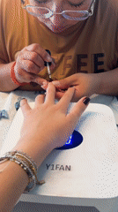 Dark red manicure in progress under a UV lamp