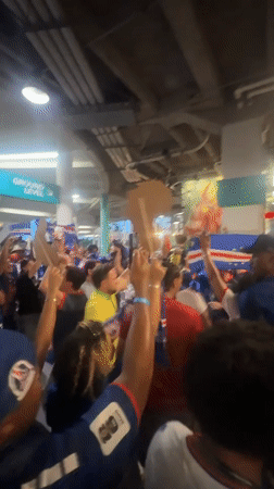 Indoor crowd waves international flags in Miami Gardens