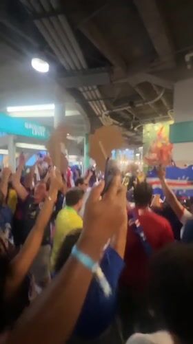 Indoor crowd waves international flags in Miami Gardens