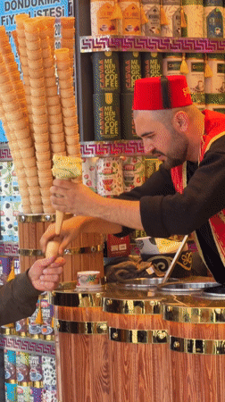 Traditional Turkish ice cream vendor serves customers in Istanbul