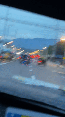 Car travels past tricycles on mountain-view road in Davao