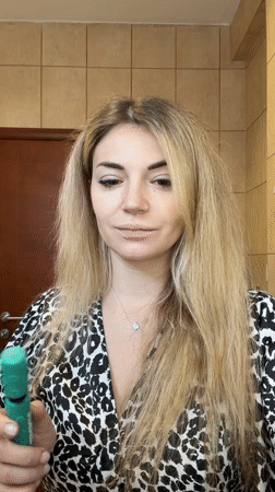 Woman applies green mascara during morning routine in Budva