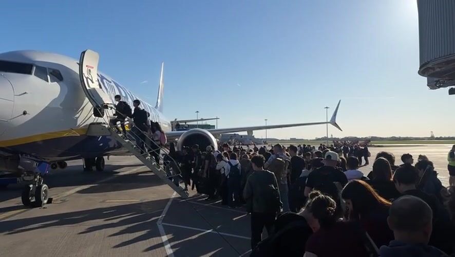 Passengers board Ryanair flight at Uttlesford airport under clear skies