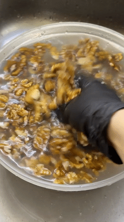 Woman prepares walnuts and berries in Izhevsk kitchen