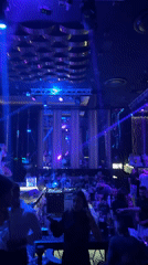 Female performer dances under blue lights at nightclub