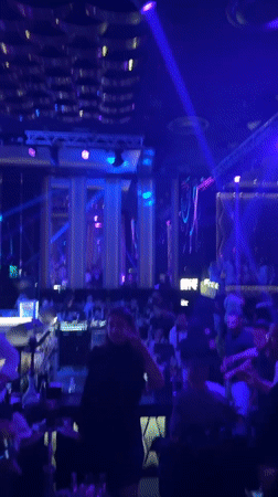 Female performer dances under blue lights at nightclub
