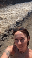 Woman films selfie video by turbulent river in Russia