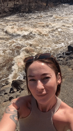 Woman films selfie video by turbulent river in Russia