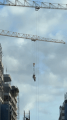Yellow crane lifts cement bucket at Cape Town construction site