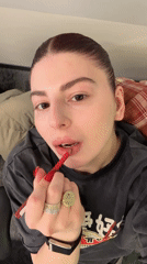Woman applies red lip liner in indoor beauty routine