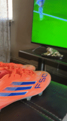 Orange Adidas soccer cleats displayed during televised match in Yerevan