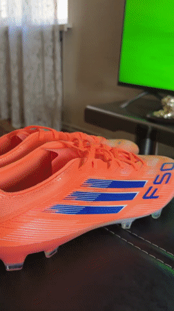 Orange Adidas soccer cleats displayed during televised match in Yerevan