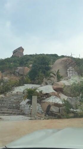 Car drives up hill road in Muddenahalli, India