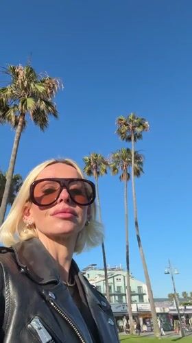 Woman photographed near Venice palm trees early morning
