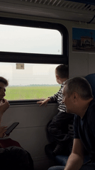 Train passengers watch countryside near Аур, Russia