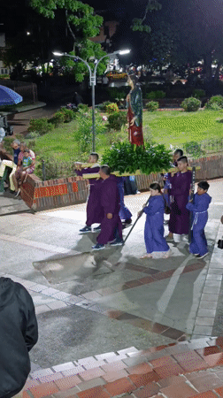 Religious procession with purple-robed participants in Timana, Colombia