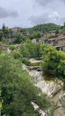 Tourists explore medieval Spanish village Rupit i Pruit suspension bridge