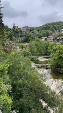 Tourists explore medieval Spanish village Rupit i Pruit suspension bridge