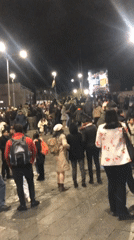 Crowds gather with Bolivian flags at nighttime La Paz demonstration