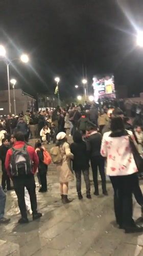 Crowds gather with Bolivian flags at nighttime La Paz demonstration