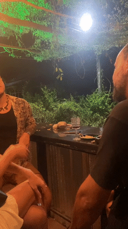 Three people gather at outdoor bar in Thailand