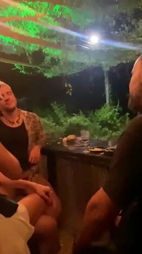 Three people gather at outdoor bar in Thailand