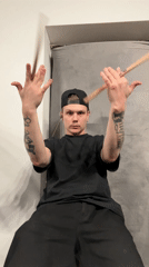 Tattooed drummer practices stick movements in Шemyakino, Russia
