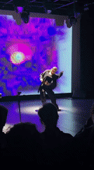 Stage dancer performs in black attire during evening show