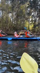 Kayakers navigate waterway in Khimki wearing safety gear