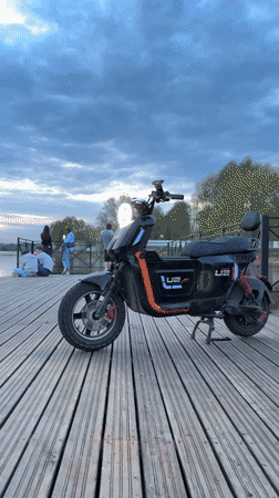 Scooter parked on pier as people gather in Veliky Novgorod