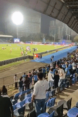 Soccer match ends as players shake hands, fans watch
