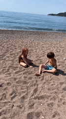 Children and dogs enjoy morning beach time in Montenegro