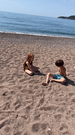 Children and dogs enjoy morning beach time in Montenegro