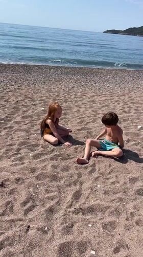 Children and dogs enjoy morning beach time in Montenegro