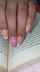 Manicured hand rests on book in Juan Griego
