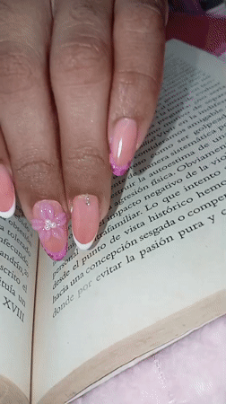 Manicured hand rests on book in Juan Griego