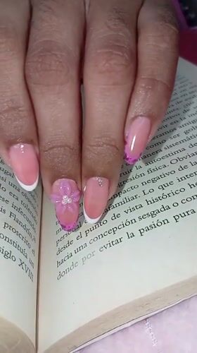 Manicured hand rests on book in Juan Griego