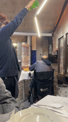 Person pours cider at outdoor restaurant in Gijón, Spain