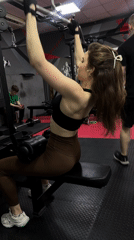 Woman exercises on lat pulldown machine at Ufa gym
