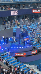 Packed stadium hosts live event with stage and sport setup