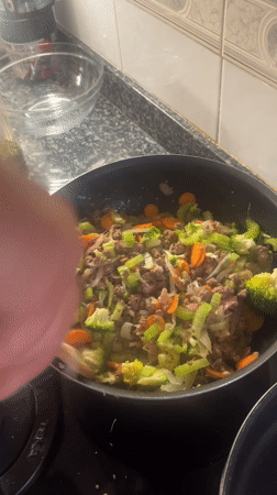 Person showcases Bitcoin coin and sneaker in Barcelona suburb