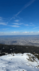 Snow-covered mountain with ski tracks observed under clear skies