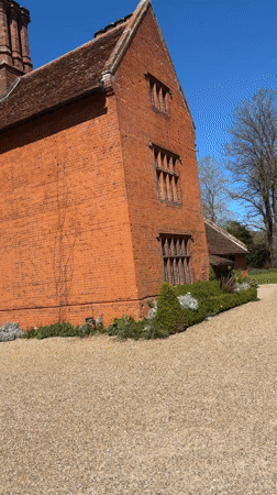 Ivy-covered brick building observed in Sutton during sunny day