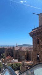 Barcelona escalator ride captures rooftop statue, cityscape view