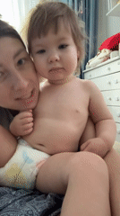 Toddler in tiger costume meets the family cat at home
