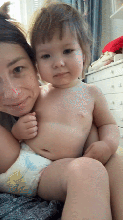 Toddler in tiger costume meets the family cat at home