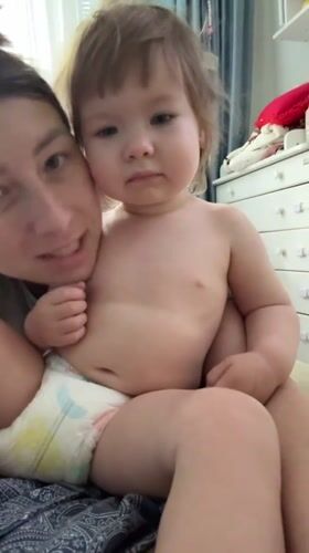 Toddler in tiger costume meets the family cat at home